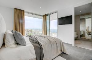 Un dormitorio con una cama grande con una ventana grande. en Villa Izabele Orange, en Callao Salvaje