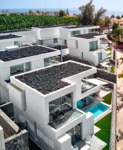 una vista aérea de un edificio de apartamentos blanco con piscina en Villa Izabele Orange, en Callao Salvaje