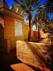 ein Gebäude mit Palmen davor in der Unterkunft منتجع شرفا السياحي البيئي in Ha'il