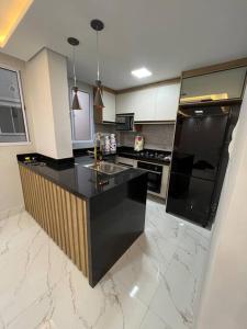 a kitchen with a black counter top in a room at Lindo apartamento em Cuiabá in Cuiabá