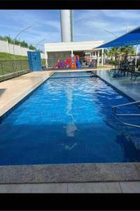 a swimming pool with blue water and a playground at Lindo apartamento em Cuiabá in Cuiabá