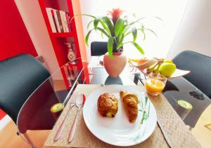a table with a plate of croissants and orange juice at L'Art de la Sérénité - Prime Host - Calme & Confort in LʼHay-les-Roses