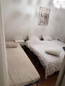 2 Einzelbetten in einem Zimmer mit einem Bild an der Wand in der Unterkunft Top in Oulu