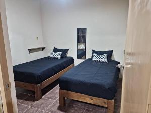 2 Betten in einem Zimmer mit offener Tür in der Unterkunft El Rincón de Petunio in Sayula