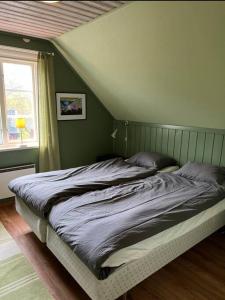 a bed in a bedroom with a green wall at precis intill Ombergs golfbana, nära till Vättern, stora Lund och Hästholmen in Ödeshög