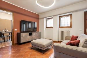 sala de estar con sofá y TV en We Home - Maison San Zeno, Verona, en Verona
