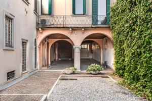 un callejón con dos macetas delante de un edificio en We Home - Maison San Zeno, Verona, en Verona