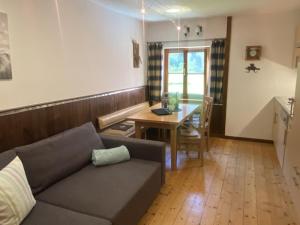 a living room with a couch and a table at Hansenbauernhof inkl. Chiemgaukarte in Ruhpolding