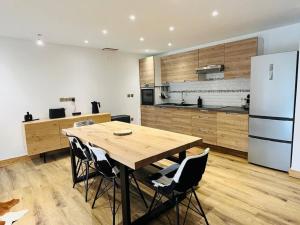a kitchen with a wooden table and a refrigerator at Coup de coeur Montagnard - 2 chambres - Cheminée - Garage in Isola 2000 +24 photos