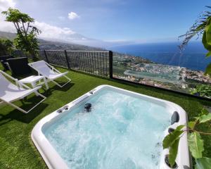 a hot tub on a balcony with a view of the ocean at Villa Canela in Sauzal