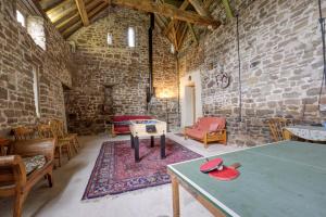 Historic cottage in the beautiful Wye Valley في Saint Briavels: غرفة مع طاولة تنس وكراسي