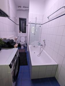 een witte badkamer met een bad en een toilet bij Schönes 3 Zimmer Apartment in der Altstadt von Koblenz in Koblenz