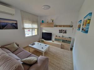 uma sala de estar com um sofá e uma mesa em Beach Apartment Regueral em Cambrils