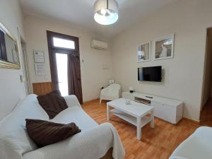 ein Wohnzimmer mit einem weißen Sofa und einem Tisch in der Unterkunft Apartamento Centro Jerez Carbón in Jerez de la Frontera