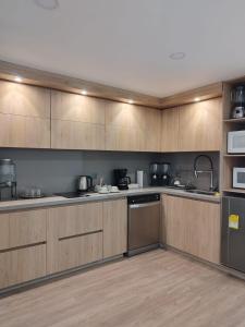 uma grande cozinha com armários de madeira e electrodomésticos de aço inoxidável em Eurolan 93 em Bogotá