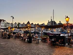 a group of people sitting at tables near a marina at Boutique Hotel De Grote Kade in Goes +10 photos