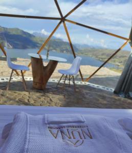1 cama con 2 sillas y mesa con vistas en Glamping Nuna Experience, en Andahuaylas