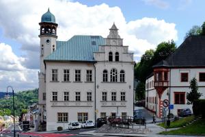 um grande edifício branco com uma torre de relógio em Fox Apartment em Jáchymov