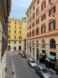 eine Stadtstraße mit Autos, die vor den Gebäuden geparkt sind in der Unterkunft Ludovisi Barberini Grand Apartment in Rom