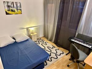 a bedroom with a bed and a desk and a keyboard at La C@sa: Appartement lumineux de 4pièces / 3ch/ Balcon/ Parking in Bagnolet