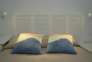 a bed with two pillows on top of it at VolcanoKite Apartments in Famara