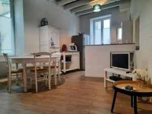 a living room with a table and a kitchen at La Palme de Retz in Pornic