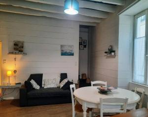 a living room with a couch and a table at La Palme de Retz in Pornic +19 photos