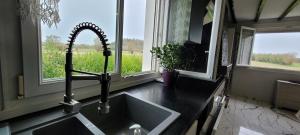 eine Küche mit einem Waschbecken und einem großen Fenster in der Unterkunft Belle maison de vacances entre Saint-Malo et Mont-Saint-Michel. Le Clos Fleuri in Mont-Dol + 53 Fotos
