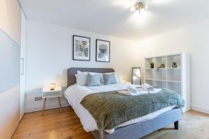 a bedroom with a bed with two towels on it at Central Thames View 3BR by Sullivan Stays in London