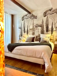 アンデューズにあるAppartement Lavande et Jasminのベッドルーム1室(壁に絵画が描かれた大型ベッド1台付)