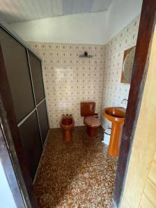 baño con 2 aseos y lavamanos en Casinha da vovó, en Tutóia