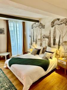 a bedroom with a large bed with a painting on the wall at Appartement Lavande et Jasmin in Anduze