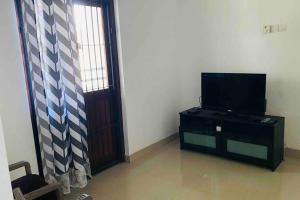 ein Wohnzimmer mit einem TV und einer Tür in der Unterkunft Catherine Villa in Ja Ela near Colombo Airport Expressway Exit in Ja-Ela