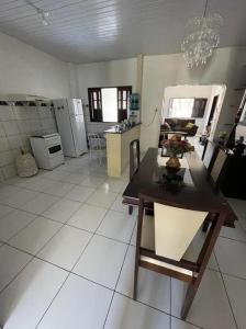 ein Wohnzimmer mit einem Tisch und einer Küche in der Unterkunft Casinha da vovó in Tutóia