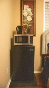 a microwave sitting on top of a refrigerator at Riz Khan Peaceful Mississauga Home in Mississauga