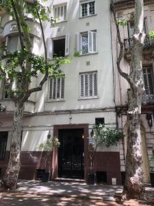 duży biały budynek z drzewami przed nim w obiekcie Edificio Quijano w mieście Montevideo