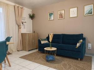 uma sala de estar com um sofá azul e uma mesa em Kedge 9 - proche centre, tram & universités em Talence