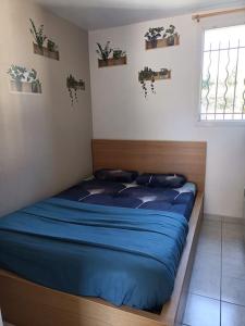 a bedroom with a bed with blue sheets and a window at Kedge 9 - proche centre, tram & universités in Talence