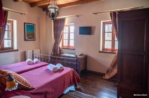 a bedroom with two beds with towels on them at Petradi 1873 in Kalarrites