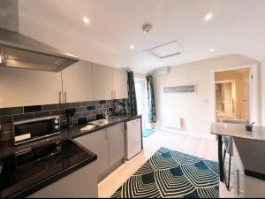 a kitchen with white cabinets and black counter tops at Taunton Flats in Taunton