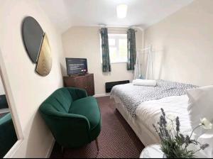 sypialnia z zielonym krzesłem i łóżkiem w obiekcie Taunton Flats w mieście Taunton