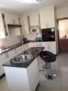 a kitchen with a sink and a chair in it at Casa MaSa Inn in Francistown