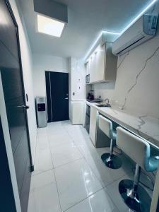 a white kitchen with a sink and a counter top at Departamento ejecutivo nuevo in Ciudad Obregón +5 photos