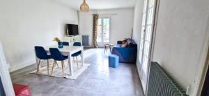 un soggiorno con tavolo e sedie blu di Maison & SPA, Terrasse & Jardin, Parking a Plan-de-Cuques