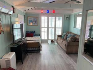 een woonkamer met een bank en een tv bij Bayside Cottage in Clearwater Beach