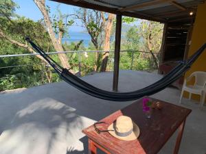 a hammock on a porch with a table and a hat at Casa Alemán in Flores