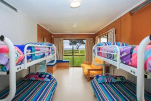 a room with bunk beds in a train at Sandy Bay Beachfront in Matapouri