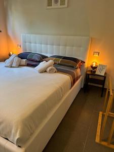 a large white bed in a room with a table at IL GIARDINETTO DI ELELU' Private Garage in Orvieto