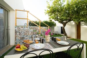 una mesa con platos de fruta en el balcón en Villa Loria en San Vito lo Capo