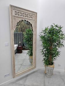 a mirror in a room with two potted plants at JUWEL Apartments Kraków Indyjski 29 in Kraków